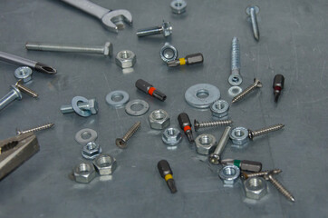 tools, bolts, and screws scattered on the metal table. nuts, bits, the texture of the workspace. voborochny focus