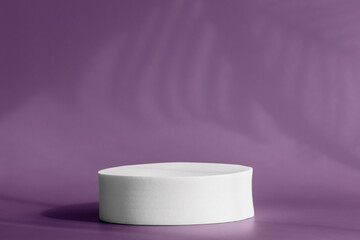 Circle platform stage for cosmetic products with tropical plant shadow on wall. Round pedestal podium for packaging presentation on violet backdrop with palm leaves shadows. Minimalist style