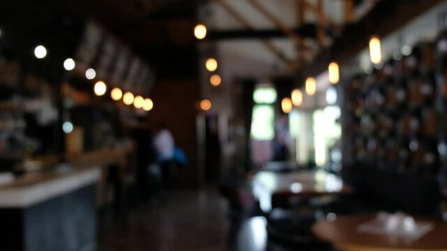Blurred pub background. A visitor passes in the background to make an order at the bar and leaves.
