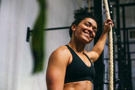 Positive Hispanic sportswoman during break in gym 
