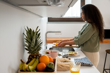Black woman preparing healthy meal in home kitchen