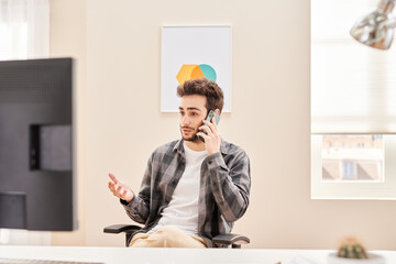 Modern male worker having phone call in office