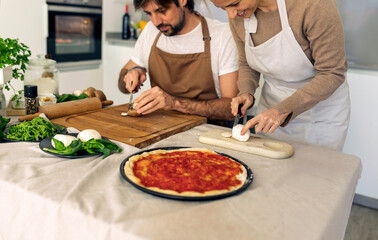 couple cooking pizza at home