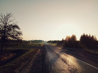 Naklejka na ściany i meble Evening road on the background of the sunset