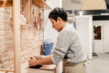 Female artisan preparing clay in the pottery workshop.