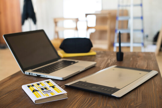 Minimalistic Workspace With Laptop And Book About NFT And Crypto Art 