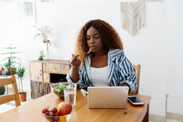 Woman tele working at home while eating a salad