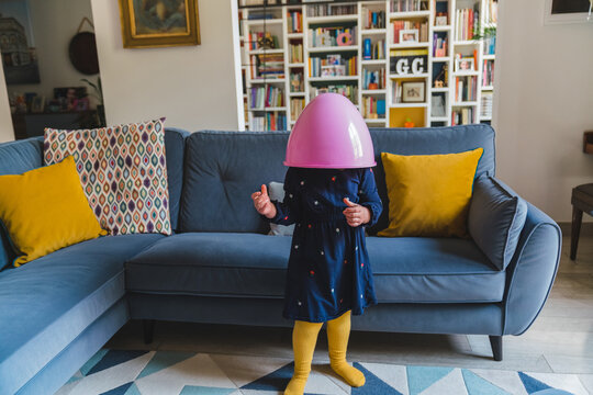 Little Girl with Easter Egg over her Head Playing at Home