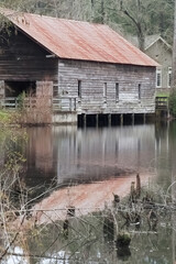 Weathered wooden building with a tin roof over a waterfall