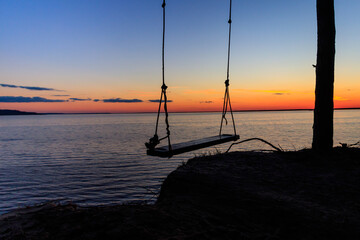 Rope swing on a shore of the Dnieper river in Ukraine at sunset