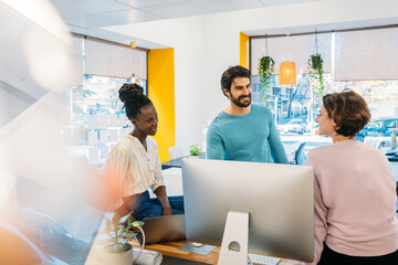 Multiracial coworkers working with gadgets in office