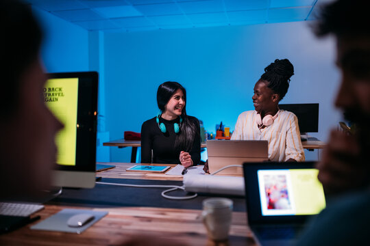 Smiling diverse colleagues working on laptop together