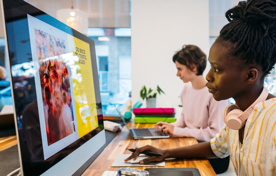 Diverse colleagues working on modern gadgets in office