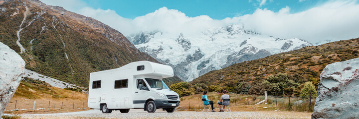 Camper camper van RV roadtrip op Nieuw-Zeeland. Koppel op reisvakantie-avontuur. Toeristen kijken naar het Aoraki Mount Cook National park en de bergen naast de huurauto. Panoramische banner
