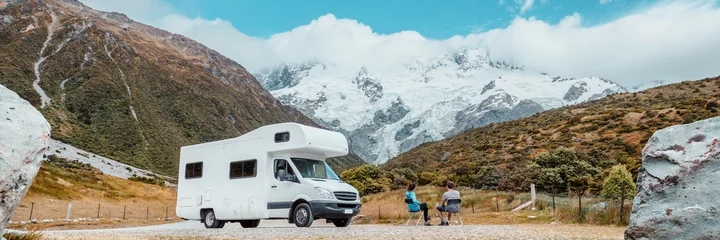 Wall murals Aoraki/Mount Cook Motorhome camper van RV road trip on New Zealand. Couple on travel vacation adventure. Tourists looking at view of Aoraki Mount Cook National park and mountains next to rental car. Panoramic banner