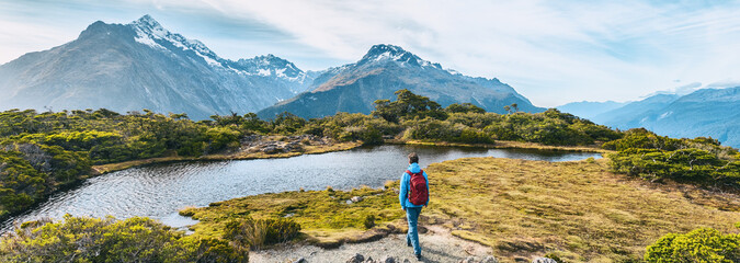 New Zealand Hiking. Young hiking man walking on trail at Routeburn Track during sunny day. Hiker...
