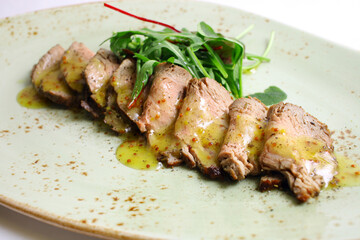 Sliced Peking Duck served with sauce, fresh salad, on white background
