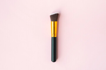 Makeup brush on a pink background. Flat lay top view