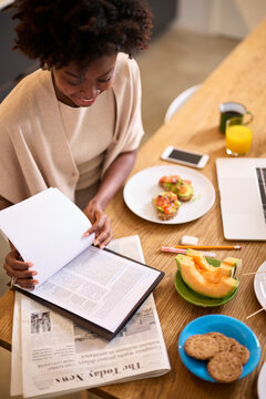 Afro American woman reading fresh information in morning.