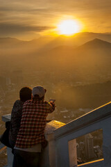 ouple looking at the landscape in cerro san cristobal at sunset