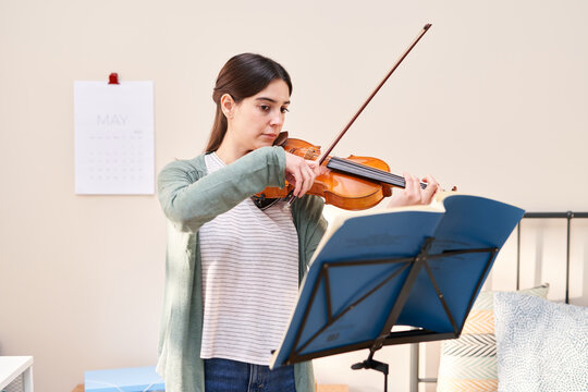 Woman practicing violin.