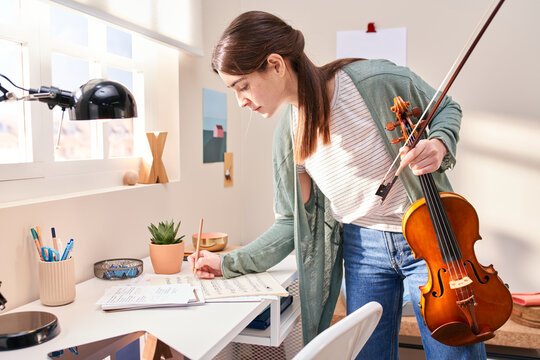 Musician taking notes in sheet music.