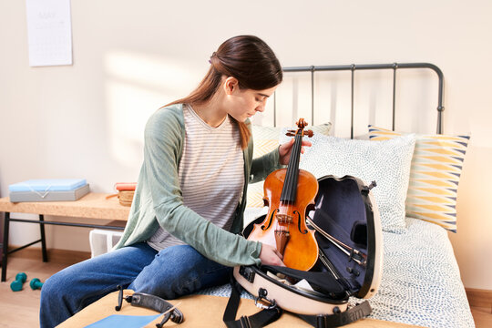 Violinist putting musical instrument in case.