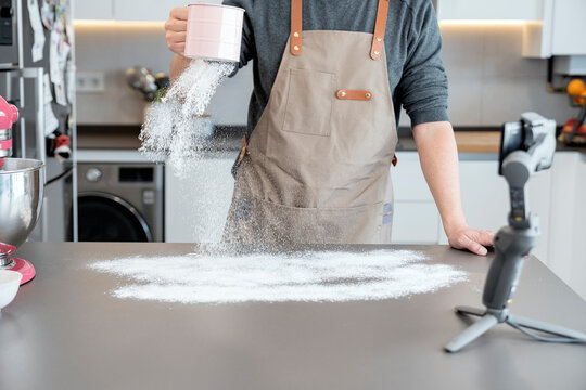Man dusting with flour a kitchen table