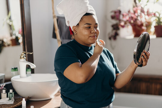 Cheerful  woman removing make up with facial tonic