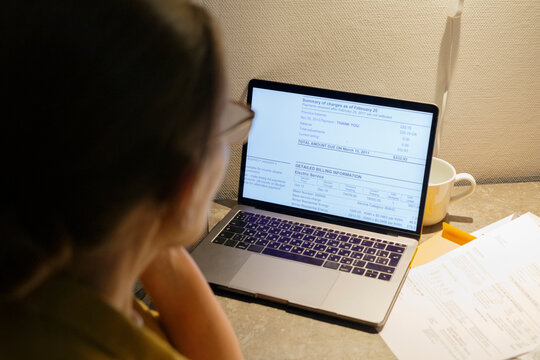 Unrecognizable woman reading data on laptop
