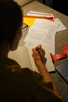 Female calculating taxes in evening at home