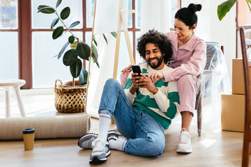 Multiracial couple using smartphone during relocation