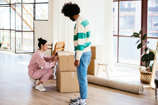 Multiracial couple packing belongings during relocation
