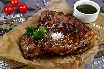 Beef steak with twig rosemary on dark wooden table with ingredients