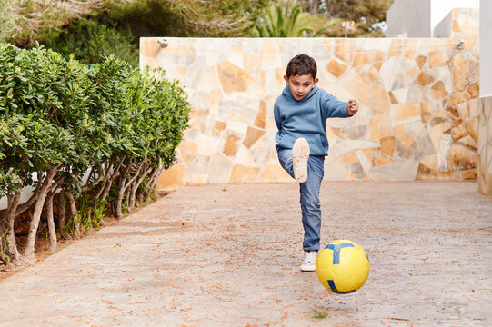 Cute little boy playing soccer outside