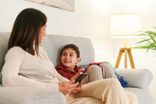 Smiling Mom And Son Using Digital Devices At Home