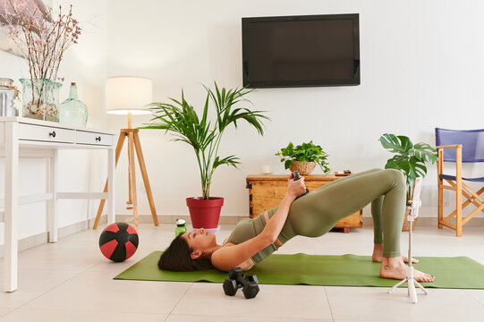 Fit woman vlogging her home workout - Powered by Adobe