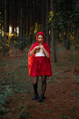 modelo disfrandose de caperucita roja en  un bosque 