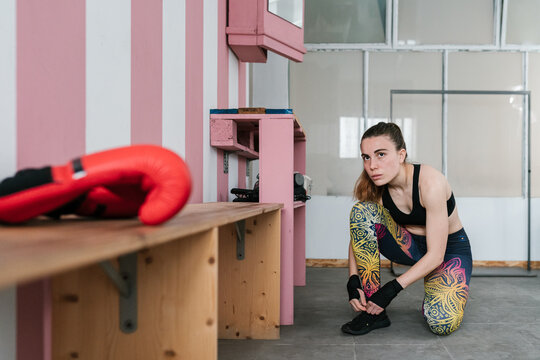 Sportswoman preparing for boxing training in changing room
