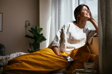 Content woman enjoying morning sun at home