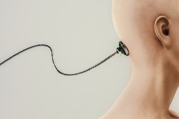 Side view of a shaved head with a wire attached to the head