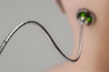 Rear view of a shaved head with a wire attached to the head