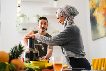 Muslim couple preparing fresh juice at home