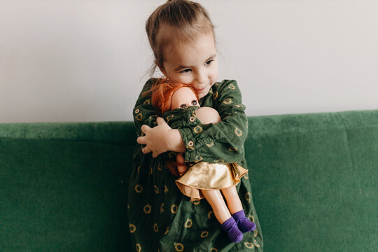 Happy little girl embracing doll
