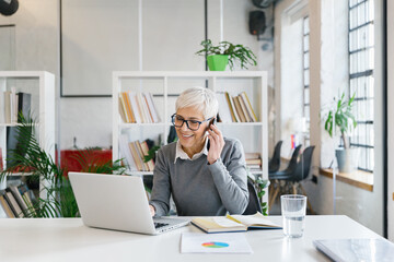 Portrait of a senior businesswoman talking on the phone in the office 