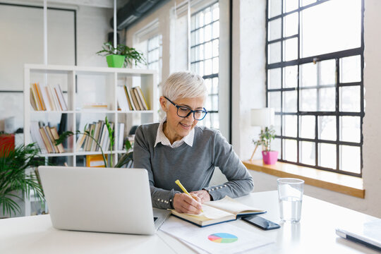Portrait of a senior businesswoman working in the office  - Powered by Adobe