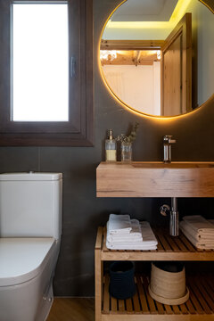 Shelves with toiletries near toilet and mirror