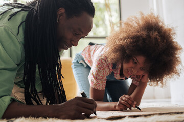 Girl and her father painting a banner in the floor