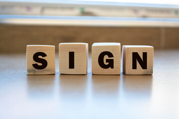 SING Word Written In Wooden Cubes On an isolated light table. Singing, karaoke or vocal training concept.