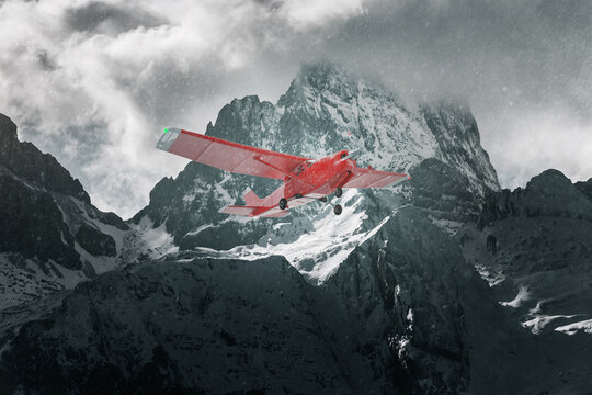 Red plane flying over snowy mountains